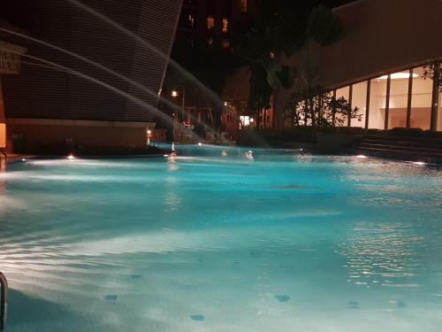 a large pool of blue water at night at White Suite At Times Square in Kuala Lumpur