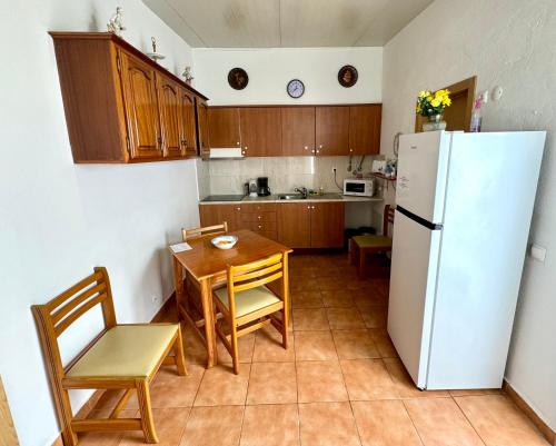 a kitchen with a table and a white refrigerator at Casa Sarguito in Sagres
