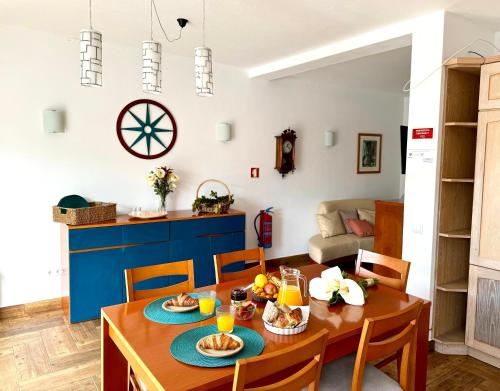 a kitchen and living room with a table and chairs at Casa Sarguito in Sagres