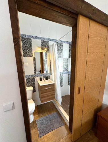 a bathroom with a toilet and a sink and a mirror at Casa Sarguito in Sagres