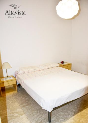 a bedroom with a white bed and a lamp at AltaVista in Ari
