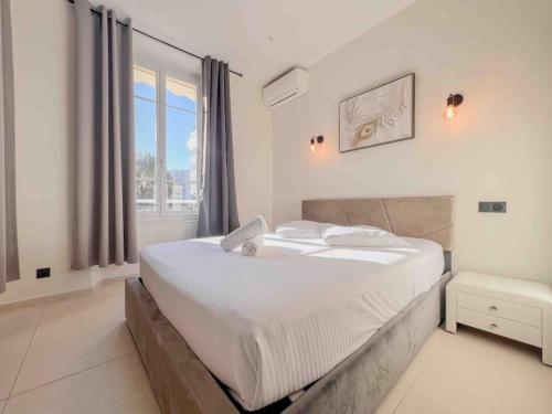 ein weißes Schlafzimmer mit einem großen Bett und einem Fenster in der Unterkunft Cannes - Luxury Apartment straight La Croisette 6Pers in Cannes