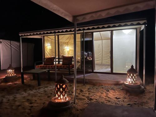 a room with a tent with a couch and lights at Merzouga Dunes Luxury Camps in Merzouga