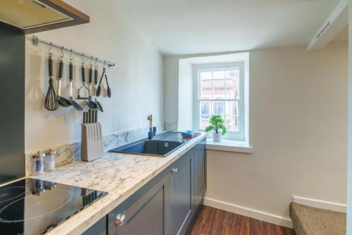 a kitchen with a sink and a window at Library View Apartment in Kendal