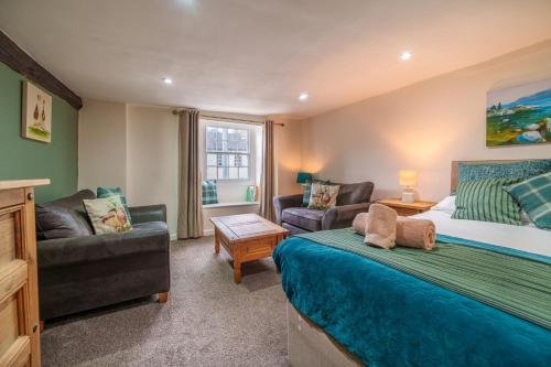 a bedroom with a bed and a living room at Library View Apartment in Kendal