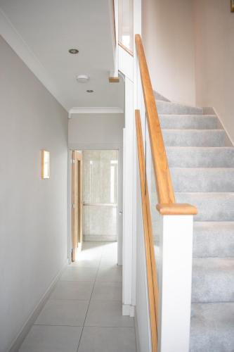 a staircase in a house with white walls and wooden railings at Spacious 6 bedroom House - Sleeps 11, Convenient Location, Perfect for FAMILIES in Birmingham