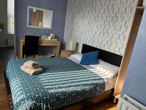 a bedroom with a bed with towels on it at Central Hotel in Sutton in Ashfield