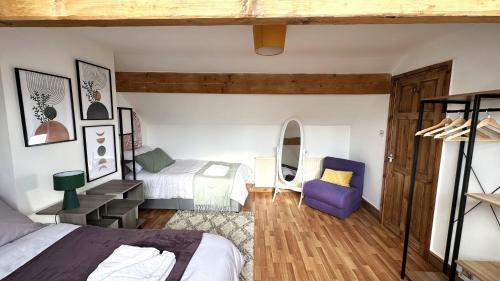 1 dormitorio con 2 camas y silla morada en Leeds Cosy House, en Leeds