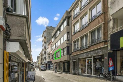 Una calle de la ciudad con edificios y una calle con gente caminando. en Entourage Christinastraat, en Ostende