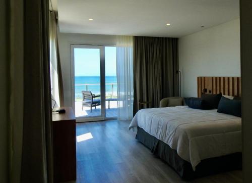 een slaapkamer met een bed en uitzicht op de oceaan bij Ili Ili Hotel Boutique in Mar del Plata