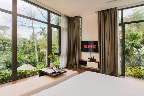 a bedroom with a large bed and large windows at Rosee Villa - Green Villa with private Pool in Vĩnh Phúc