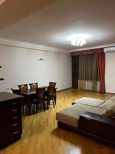 a living room with a table and a bed and a dining room at Home in Yerevan