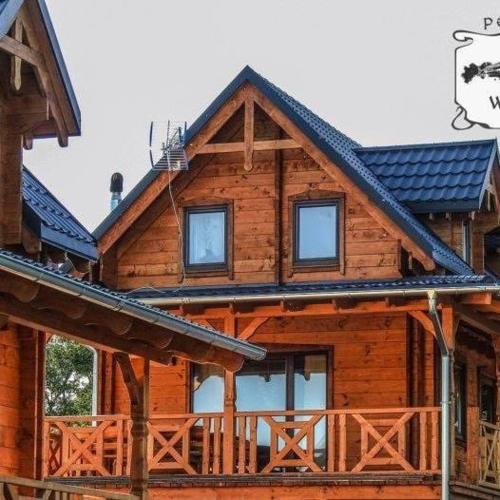 a large wooden house with windows and a roof at Domek cało roczny na Mazurach z własnym stawem nad jeziorem Ołów 