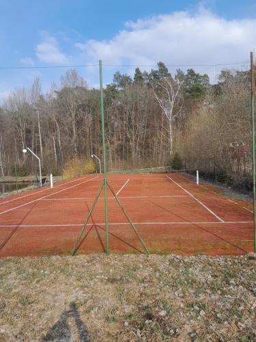 a tennis court with a net on top of it at Domek cało roczny na Mazurach z własnym stawem nad jeziorem Ołów 