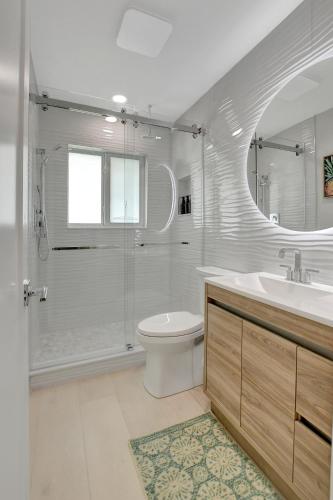 a bathroom with a toilet and a shower and a sink at Coastal Palms House in Boynton Beach