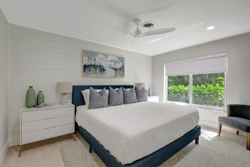 una camera con un grande letto e una finestra di Coastal Palms House a Boynton Beach