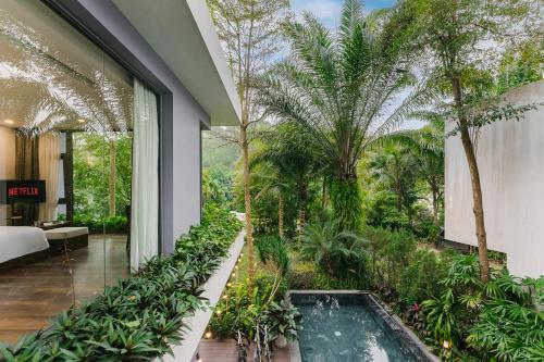 an indoor garden with a pool in the middle of a building at Rosee Villa - Green Villa with private Pool in Vĩnh Phúc