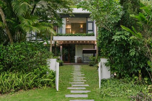 una casa con una pasarela delante de ella en Rosee Villa - Eco Green Villa in Flamigo Dai Lai Resort, en Vĩnh Phúc