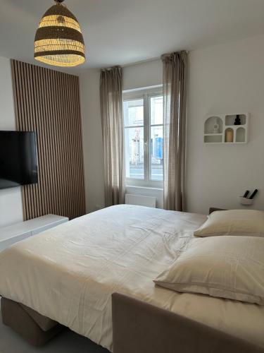 une chambre avec un grand lit et une fenêtre dans l'établissement Les Lotus - Joli F2 rénové, à Saumur