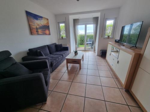 a living room with a couch and a tv at Nordseehaus Dangast in Dangast