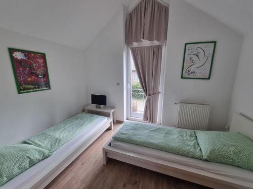 twee bedden in een kamer met een raam bij Nordseehaus Dangast in Dangast