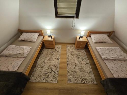 two beds in a room with two lamps on them at Brvnara ispod stare kruške in Bajina Bašta