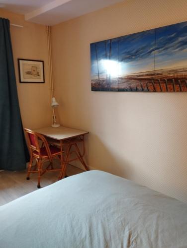 1 dormitorio con 1 cama, 1 mesa y 1 pintura en Eure et Loir- Le Catalpa, en Goussainville