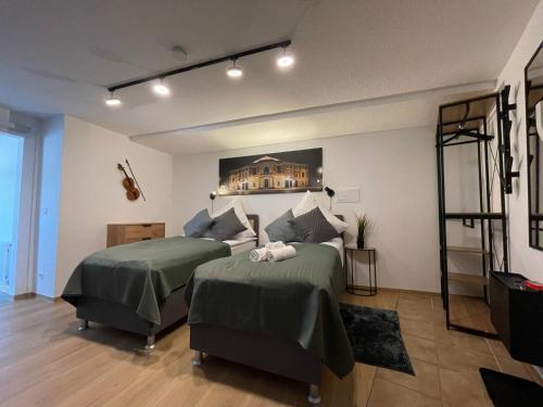 um quarto com duas camas e uma prateleira em Apartment Violine1 am Bahnhof-City em Bayreuth