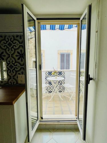 a sliding glass door leading to a patio with a table at Casa Antonia - Brand-new flat in the old town in Conversano