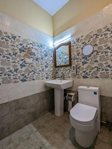 a bathroom with a toilet and a sink at Cloudwalks Homestay in Kodaikānāl