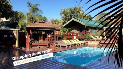 a swimming pool with a gazebo and a resort at Luxury Tented Village @ Urban Glamping in St Lucia