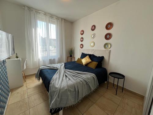 a bedroom with a bed with blue sheets and a window at L'Escale - Airport - Paris in Goussainville