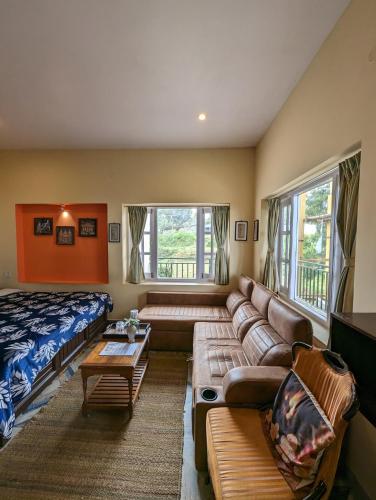 a living room with a couch and a bed at Cloudwalks Homestay in Kodaikānāl