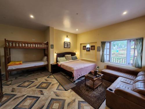 a bedroom with a bunk bed and a couch at Cloudwalks Homestay in Kodaikānāl