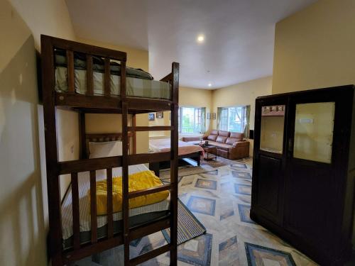 a room with two bunk beds and a living room at Cloudwalks Homestay in Kodaikānāl
