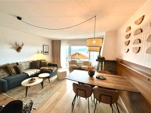 a living room with a couch and a table at Window on Crans Montana, Appartement avec vue sur les Alpes in Crans-Montana
