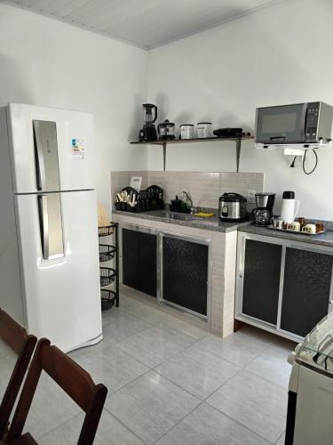 a kitchen with a refrigerator and a counter top at Casa Zago 1 in Santa Maria Madalena