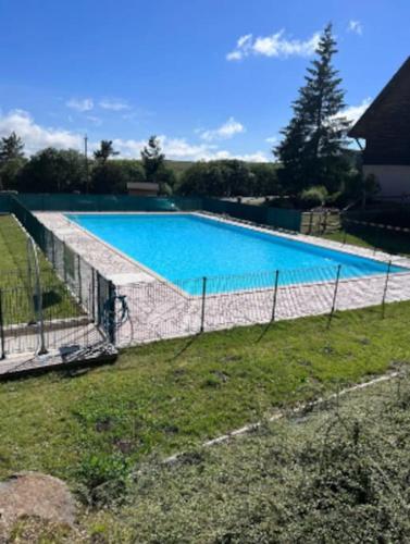 une grande piscine entourée d'une clôture. dans l'établissement Charmant Duplex pour 8 personnes avec piscine, à Besse-et-Saint-Anastaise
