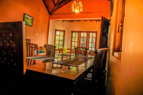 a dining room with a wooden table and chairs at GlenfallsRest in Nuwara Eliya