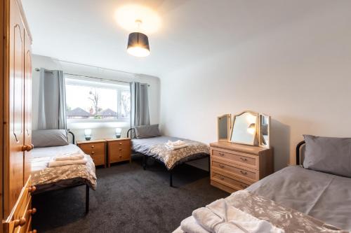 a bedroom with two beds and a mirror and a dresser at NEW - Central Modern Flat in Southampton, Sleeps 5, Free Off-Road Parking, Close to Hospital, Cruise terminal and Centre, Great for contractors, friends & families in Southampton