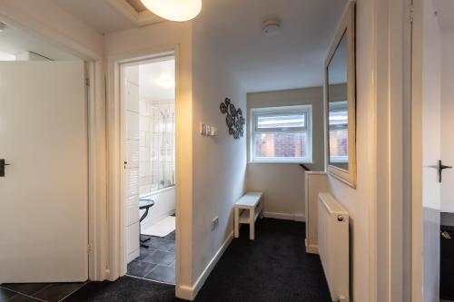 a bathroom with a toilet and a sink and a mirror at NEW - Central Modern Flat in Southampton, Sleeps 5, Free Off-Road Parking, Close to Hospital, Cruise terminal and Centre, Great for contractors, friends & families in Southampton