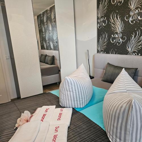 a room with two pillows on a bed with a couch at Sun Island in Baabe
