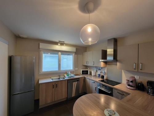 a kitchen with a sink and a table in it at Gîte du Braun in Cherbourg en Cotentin