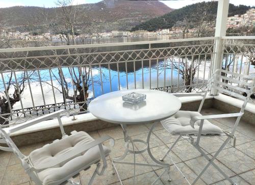 uma mesa e cadeiras numa varanda com vista para a água em Katerina studios rooms-Biker friendly hotel em Castória
