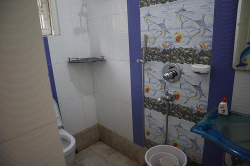 a bathroom with a shower with a sink and a toilet at SWET APARAJITA in Bolpur