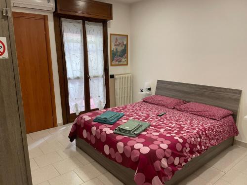 1 dormitorio con 1 cama con edredón rojo en Casa Pompei, en Vigevano
