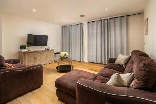 a living room with two couches and a flat screen tv at Pass the Keys Stylish Central St Albans Flat with Free Parking in St. Albans