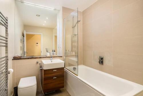 een badkamer met een bad, een wastafel en een toilet bij Pass the Keys Stylish Central St Albans Flat with Free Parking in Saint Albans