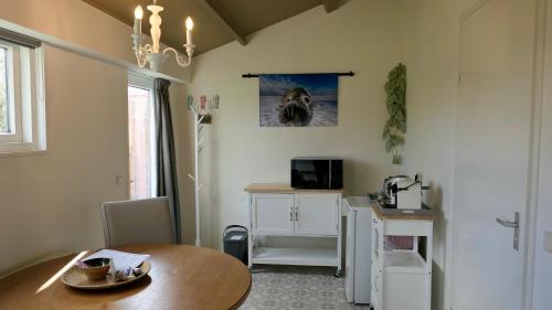 a dining room with a table and a dog picture on the wall at De Zilte Zeehoeve in Ellemeet