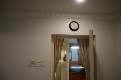 a clock on the wall above a bathroom door at SWET APARAJITA in Bolpur
